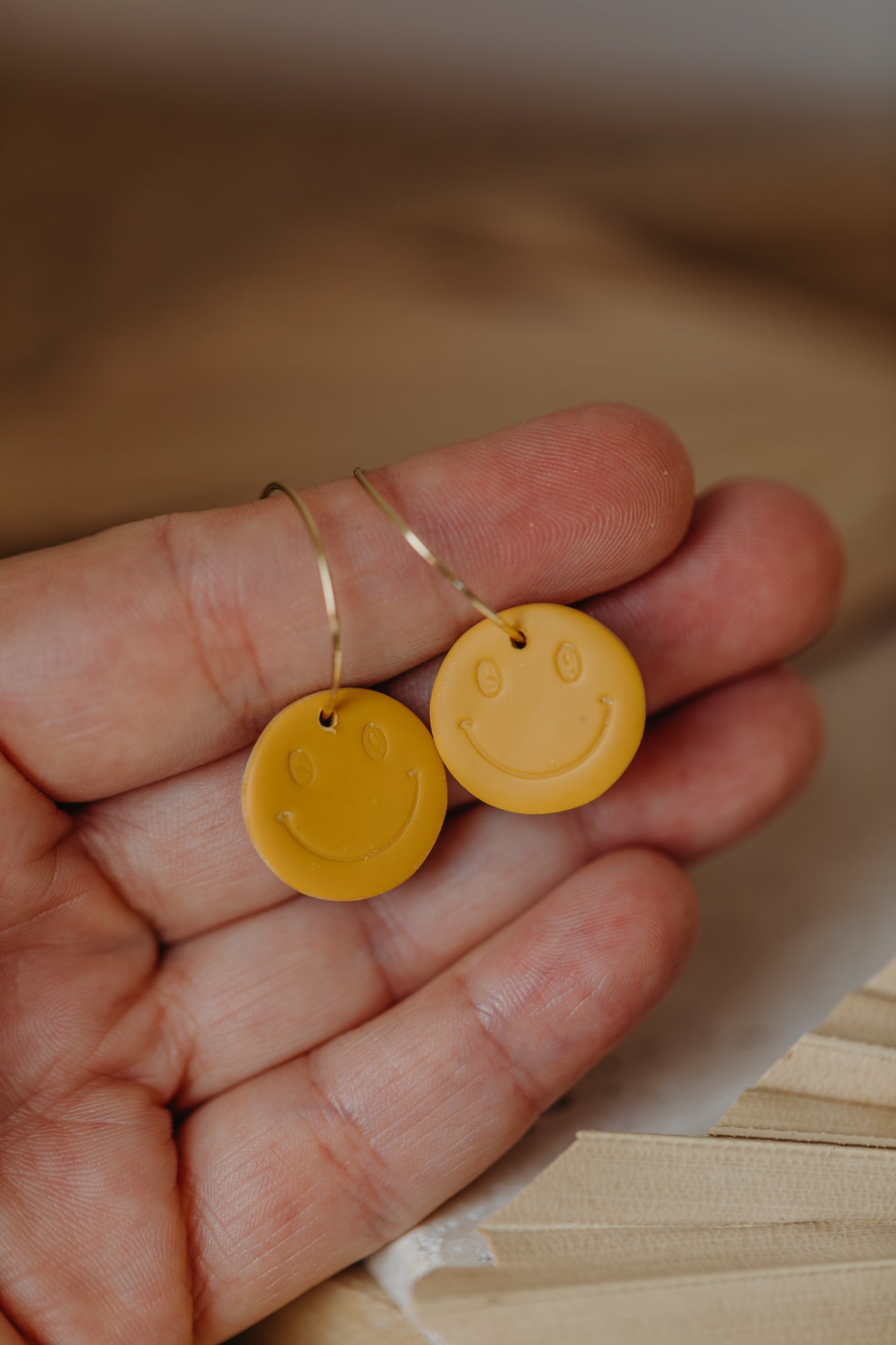 yellow smiley face hoop earrings made of polymer clay