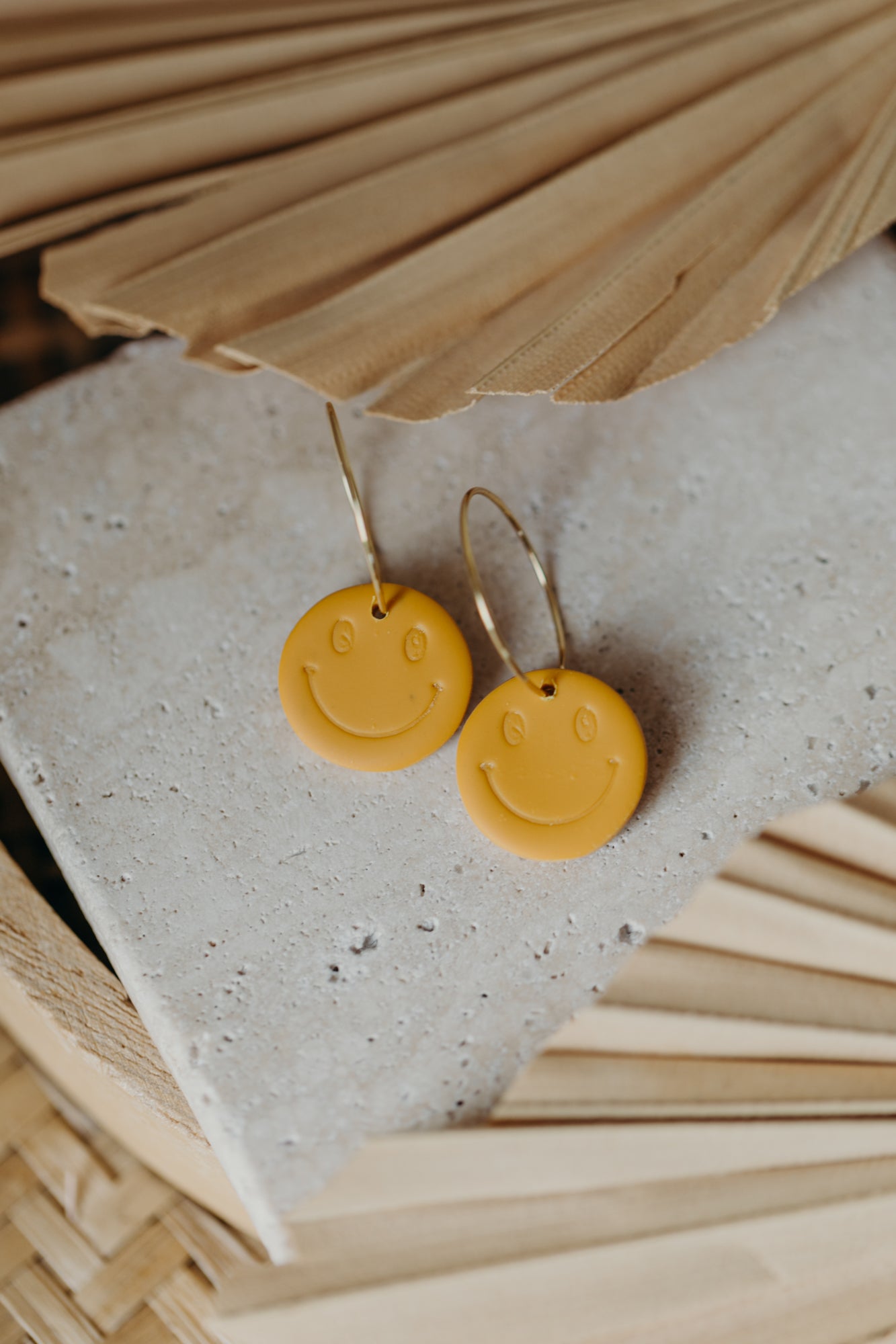 yellow smiley face hoop earrings made of polymer clay