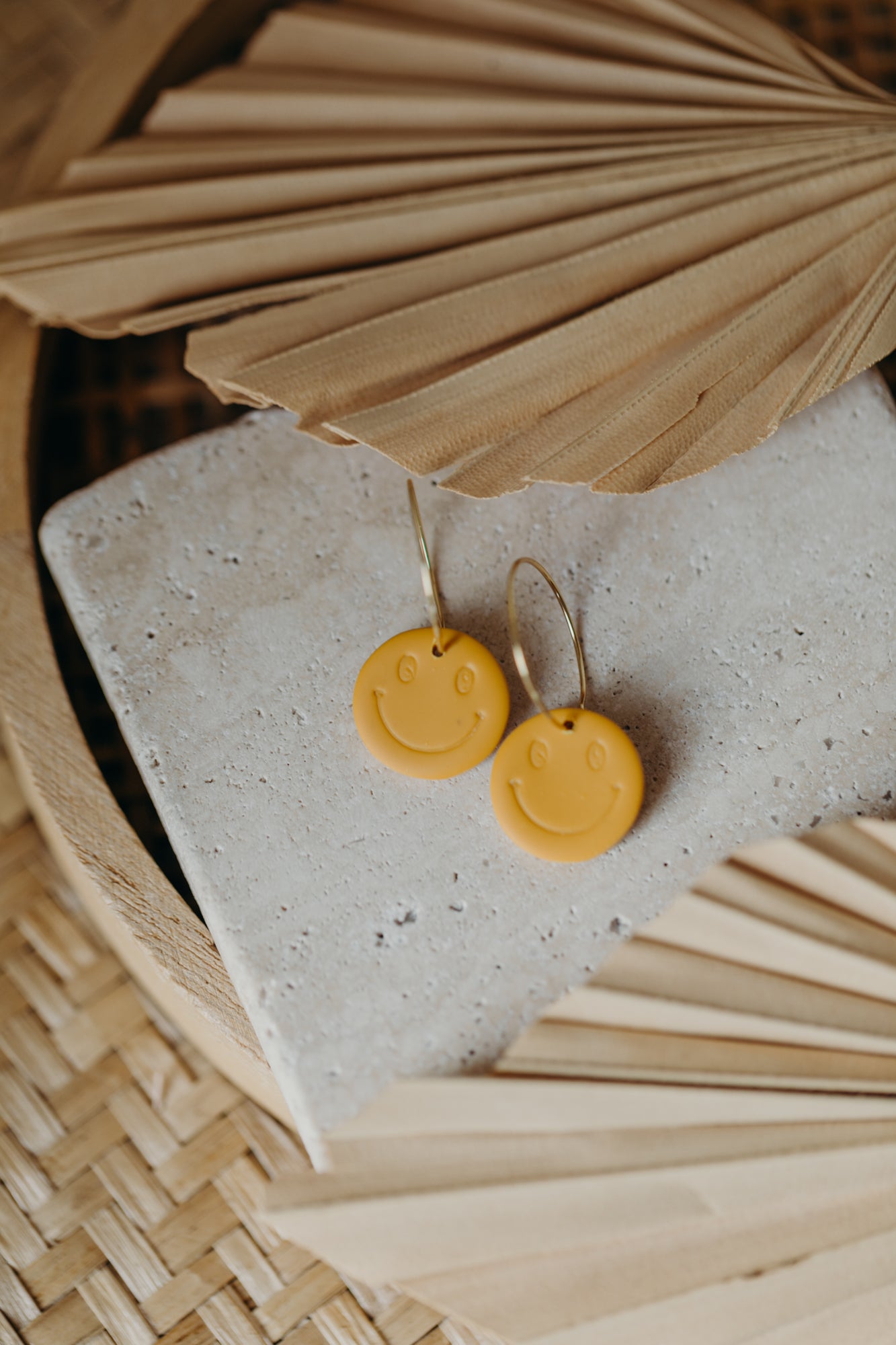 yellow smiley face hoop earrings made of polymer clay