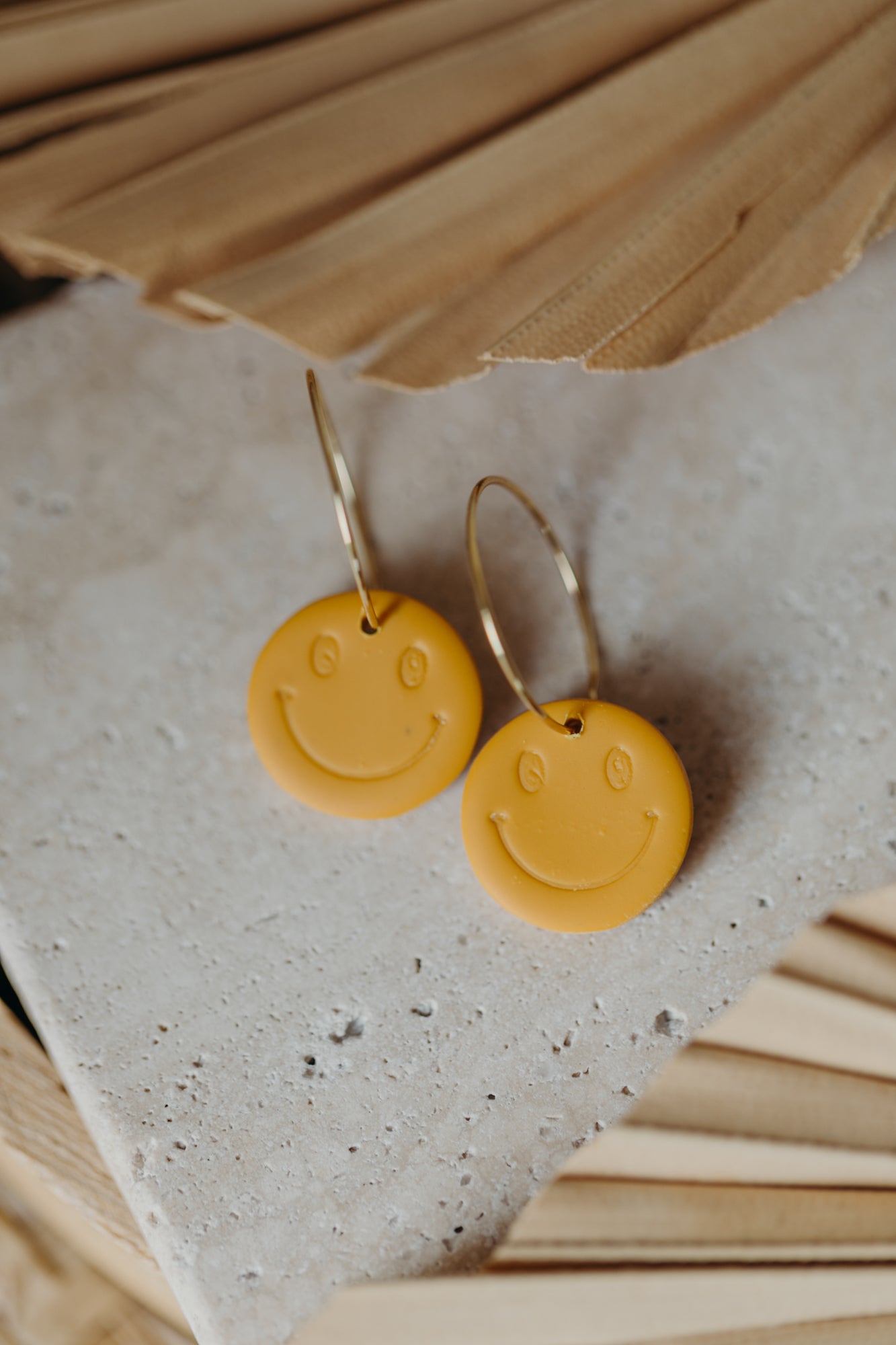 yellow smiley face hoop earrings made of polymer clay