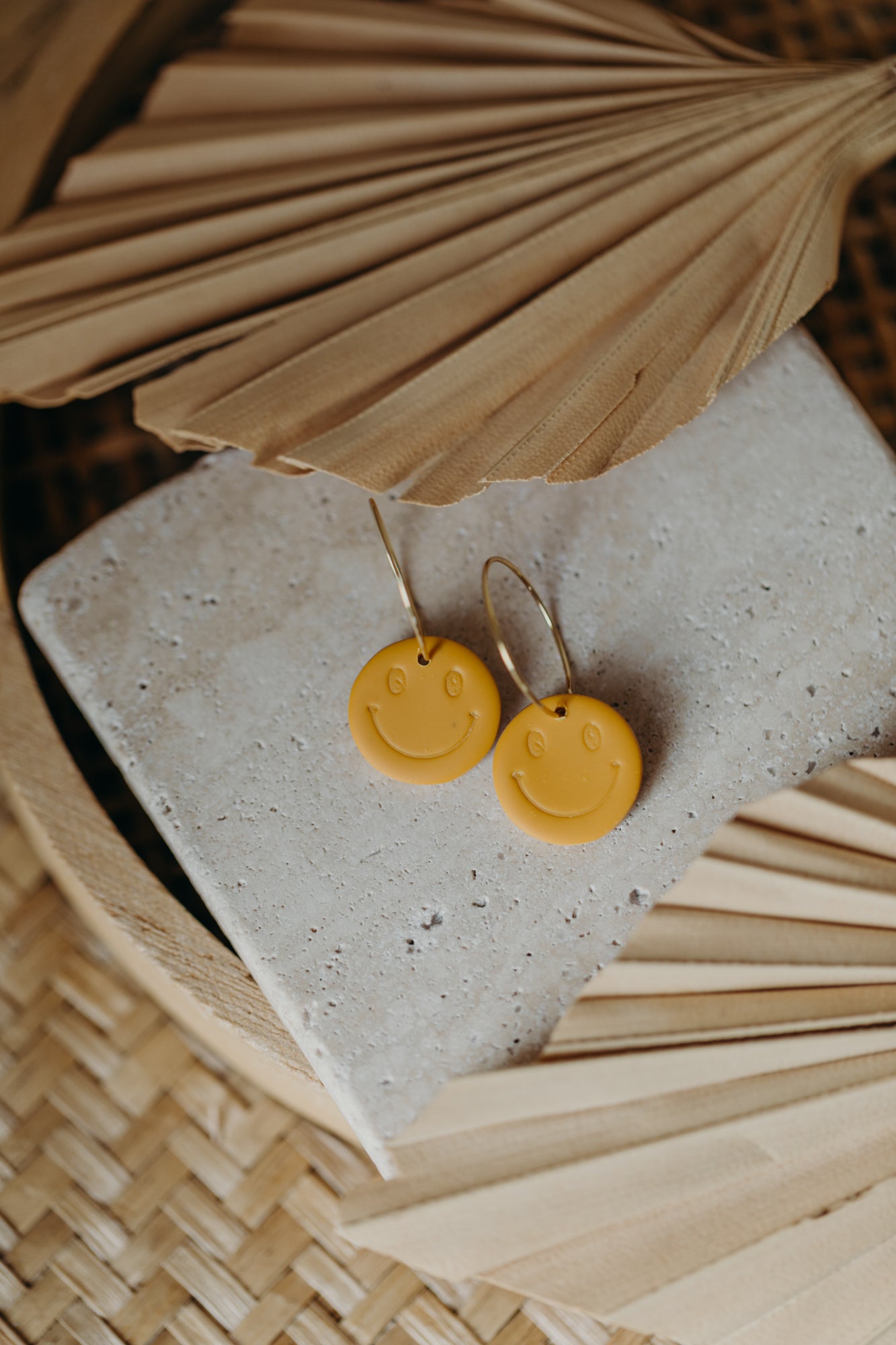 yellow smiley face hoop earrings made of polymer clay