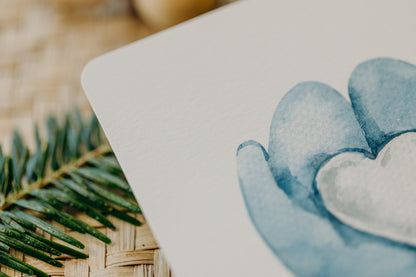 Weihnachtspostkarte blaue Handschuh mit Schnee-Herz
