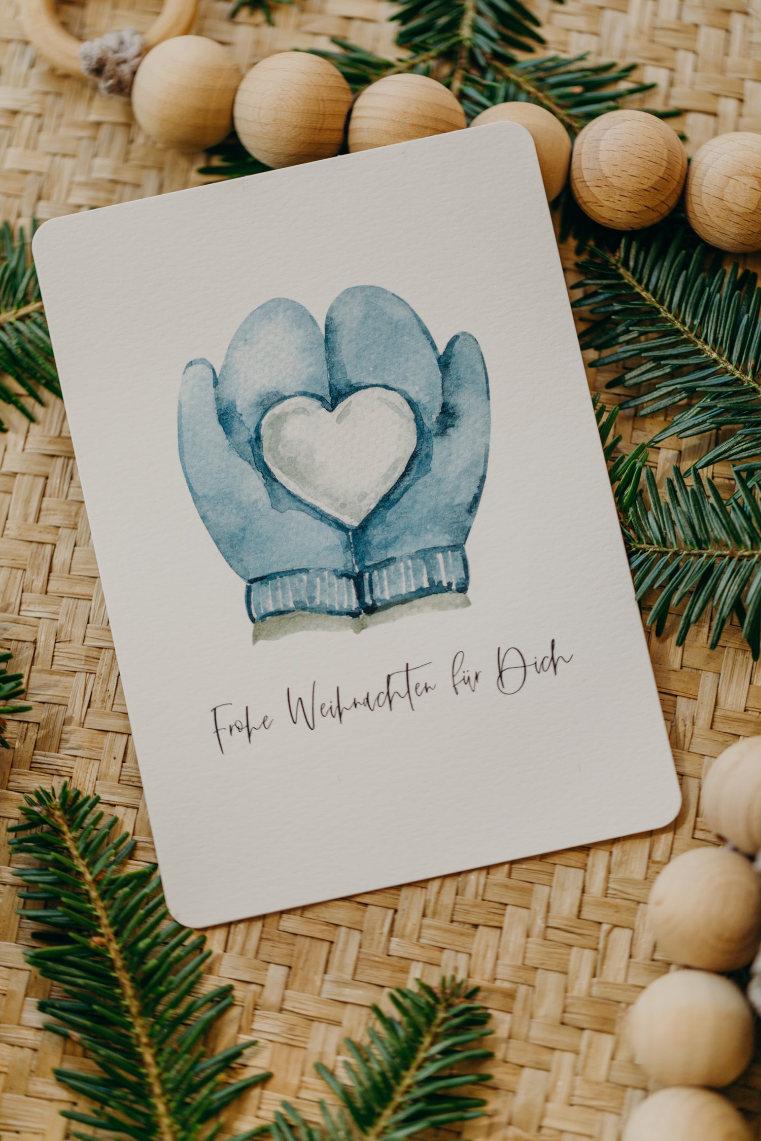 Weihnachtspostkarte blaue Handschuh mit Schnee-Herz