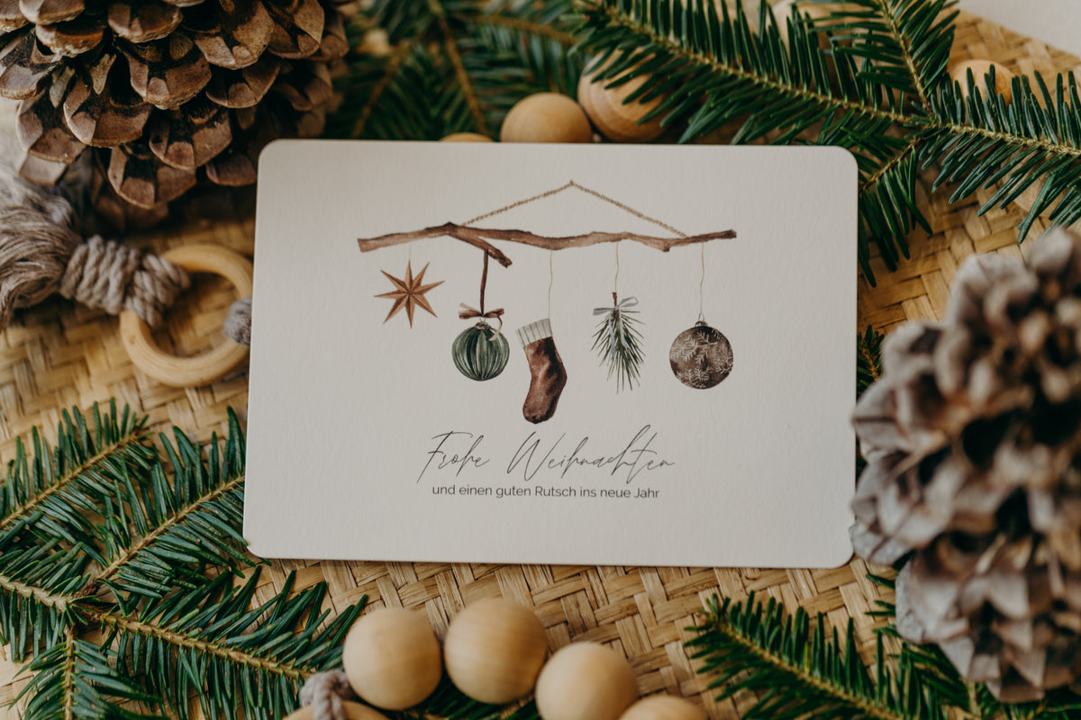 Weihnachtspostkarte Ast mit braunen Socken, Stern und Christbaumkugeln