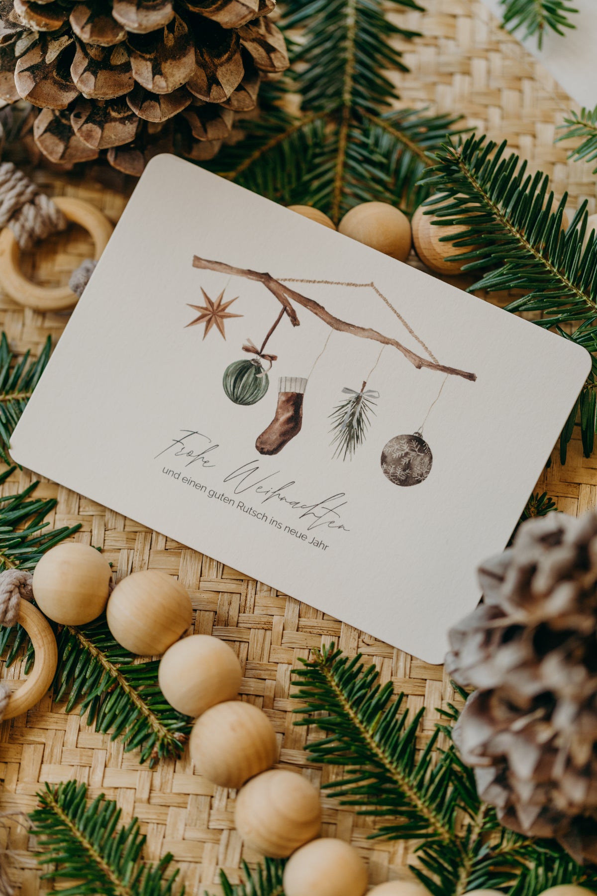 Weihnachtspostkarte Ast mit braunen Socken, Stern und Christbaumkugeln